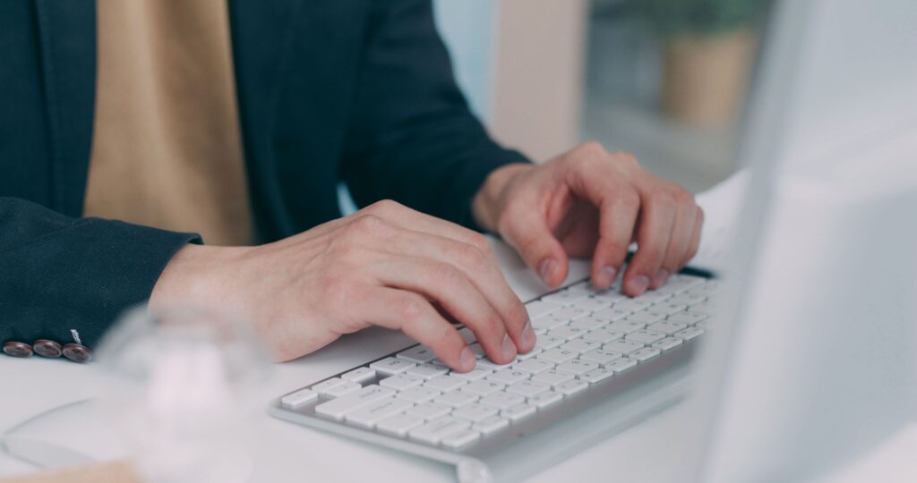 Professional reviewing an English work email on a laptop in a workplace setting