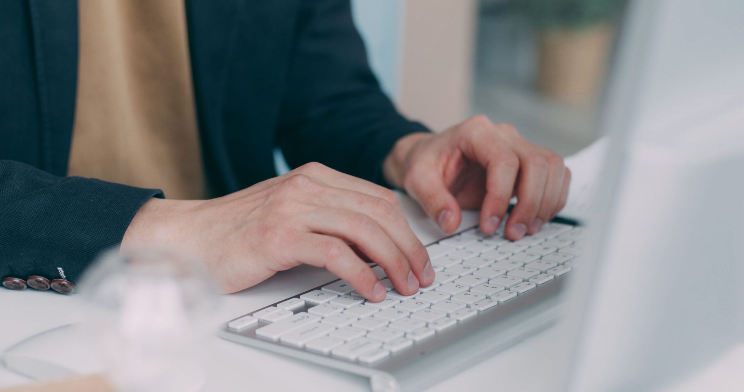 Professional writing an English work email on a laptop